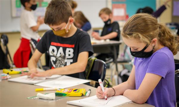 Students draw on paper